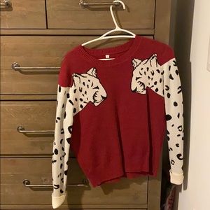 burgundy sweater with white leopards on sleeves.